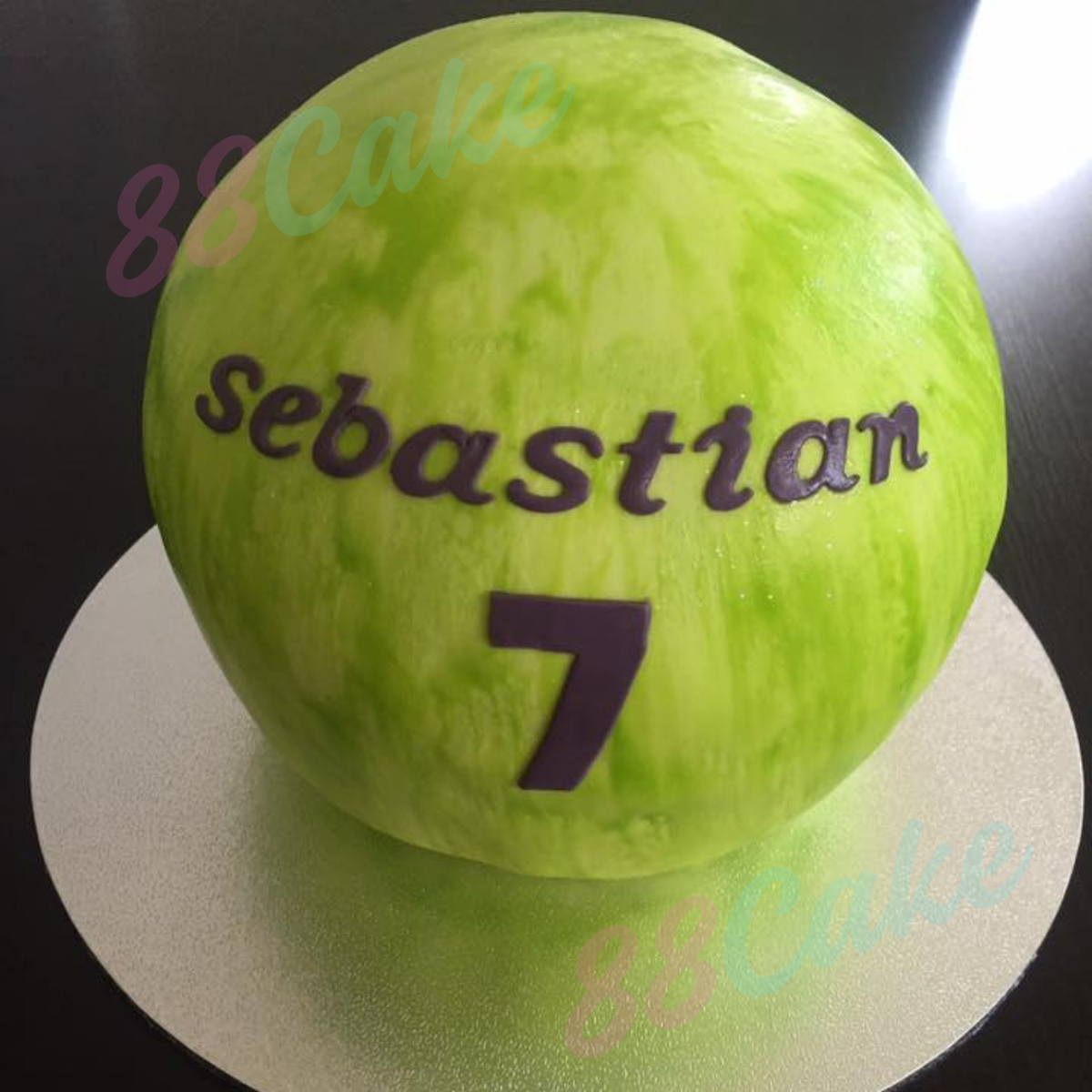 Bowling ball-shaped cake with custom name and age