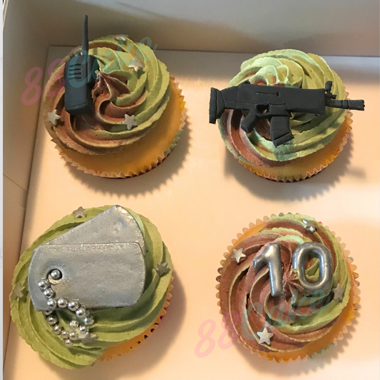 Four cupcakes with military-themed decorations including dog tags, gun, walkie talkie and number 10 