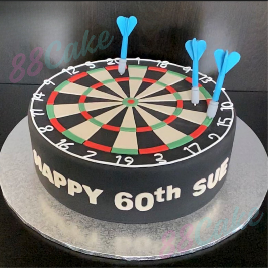 Dartboard-themed birthday cake with blue darts