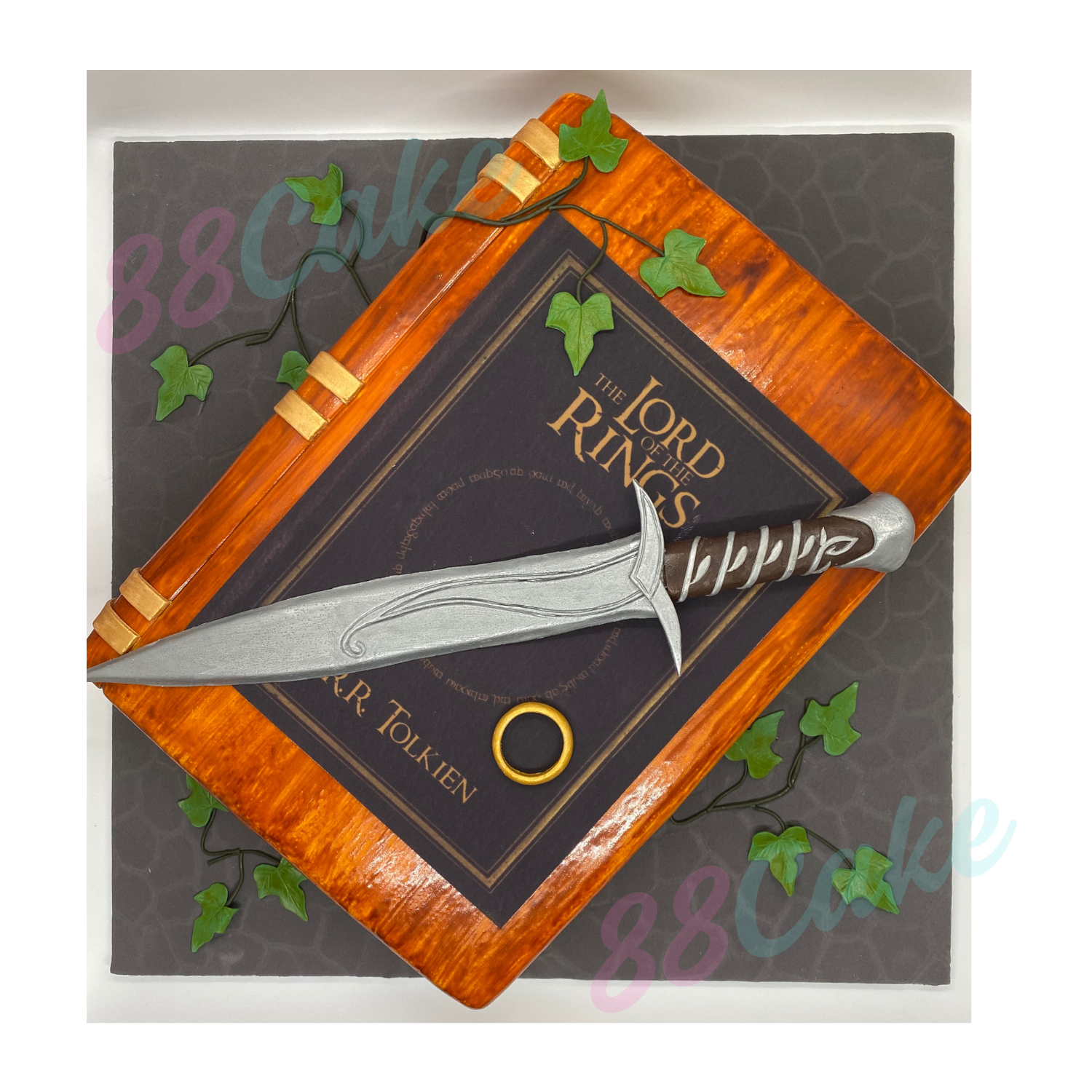 Lord of the Rings book cake decorated with a sword and ring